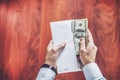 Closeup of man hands count us dollar money, male hand putting money in empty white envelope Royalty Free Stock Photo