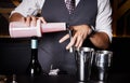 Closeup of man hands pouring alcoholic drink in to a jigger to prepare a cocktail. Royalty Free Stock Photo