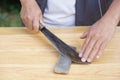 Closeup man hands sharpen knife on whetstone sharpener or grindstone. Royalty Free Stock Photo