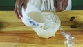 Closeup man hands by spoon make deepening in white flour and pour liquid yeast