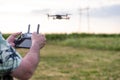 Closeup of a man holding a remote control of a drone, Flying drone on background. Selective focus Royalty Free Stock Photo