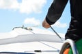 Closeup on man holding rope on the yacht, body part.