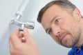 Closeup man looking at radiator tap