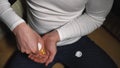 Closeup of a man pouring a lot of round vitamins on his hand from a jar and putting them in his mouth Royalty Free Stock Photo