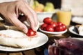 Man preparing pa amb tomaquet, bread with tomato