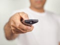 Closeup of a man press the remote controller button on white background Royalty Free Stock Photo