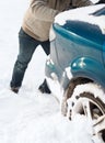 Closeup of man pushing car stuck in snow Royalty Free Stock Photo