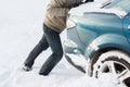 Closeup of man pushing car stuck in snow Royalty Free Stock Photo