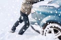 Closeup of man pushing car stuck in snow Royalty Free Stock Photo