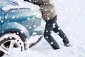 Closeup of man pushing car stuck in snow Royalty Free Stock Photo