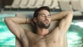 Closeup man relaxing by pool at luxury spa. Man sleeping poolside on lounger Royalty Free Stock Photo