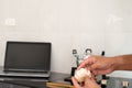 Closeup, A man's hand is holding garlic for home kitchen cooking. In the kitchen there is a pot on the gas stove.