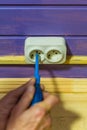 Closeup of man`s hand installing socket on wooden wall at country house Royalty Free Stock Photo