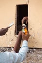 Closeup of man's hands buying alcohol through small window, Delh