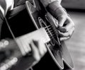 Closeup man`s hands, fingers, strumming acoustic guitar with pick Royalty Free Stock Photo