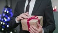 Man`s Hands Unwrapping a Christmas Gift