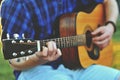 Closeup of a man`s hands strumming on acoustic guitar