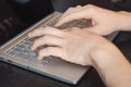 Closeup man`s hands typing on a laptop