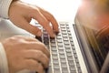 Closeup of manÃ¢â¬â¢s hands typing on laptop keyboard.