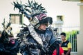 Closeup man in scary black demon costume walks by city street at dominican carnival