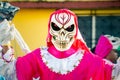 Closeup man in scary mask and costume poses for photo on dominican city street