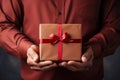 closeup man in shirt holding gift cardboard box with red bow Royalty Free Stock Photo