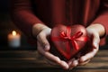 closeup man in shirt holding gift heart shaped box with red bow Royalty Free Stock Photo