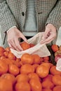 Man using a reusable mesh bag at a greengrocer