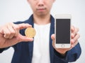 Closeup man show gold bitcoin coin and mobile phone in his hand the digital money concept crypto Royalty Free Stock Photo