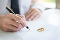 Closeup of a man Signing Contract or premarital agreement, filling petition form agreement of divorce in office at lawyer desk in Royalty Free Stock Photo