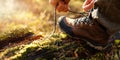 man tying hiking boot shoelace on fallen tree trunk in forest. outdoor footwear and clothing. banner with copy space Royalty Free Stock Photo