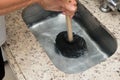 Closeup of the man using a plunger to unstop the kitchen sink. Royalty Free Stock Photo