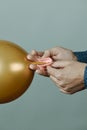 Man tying an inflated golden balloon Royalty Free Stock Photo