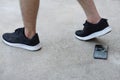 Closeup man wears black sport shoes, walking and his smartphone fell and broke on ground. Royalty Free Stock Photo