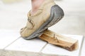 Closeup man wears shoes is stepping on rusty metal nail on wood