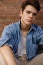 Closeup of man in white T-shirt on brick wall background Royalty Free Stock Photo