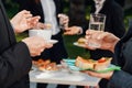 Man and woman holding coffee, water and sandwiches during business lunch