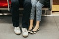 Closeup of man and woman legs in outdoor shoes together. Couple dating sitting together on seats in subway underground. Love and Royalty Free Stock Photo