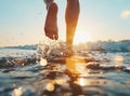 Closeup of man's feet walking on the beach during a golden sunset.