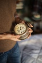 Closeup of a man's hands holding an antique small wooden clock