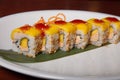 Closeup of mango sushi with foie gras, peanut and mango sauce served on a white plate