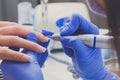 Closeup manicurist with a milling cutter for manicure. Procedure for cleansing cuticles on nails Royalty Free Stock Photo