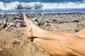 Closeup of mans feet lying on the beach