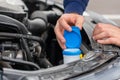 Closeup mans hands checking a level of a glass washer. Car repairing concept. Automobile service.