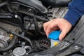 Closeup mans hands checking a level of a glass washer. Car repairing concept. Automobile service