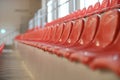 Closeup of many rows of red plastic seats in a grandstand stadium Royalty Free Stock Photo