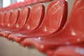 Closeup of many rows of red plastic seats in a grandstand stadium Royalty Free Stock Photo