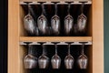 Closeup many upside down empty clear transparent crystal upturned wine glasses hanging in straight row on brown wooden Royalty Free Stock Photo