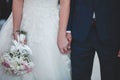 Closeup of a marrying couple holding hands during the wedding ceremony