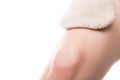 Closeup, massage glove on a female leg, isolated on white